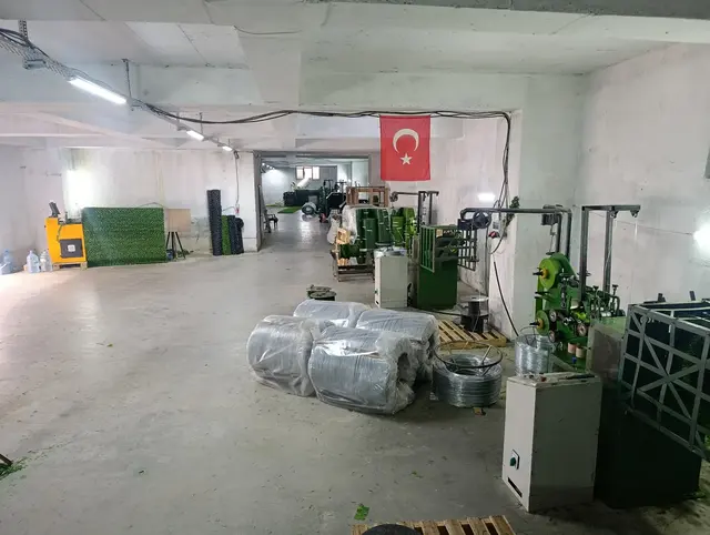 Atölyede stoklanan tel ruloları, profiller ve üretim hattı